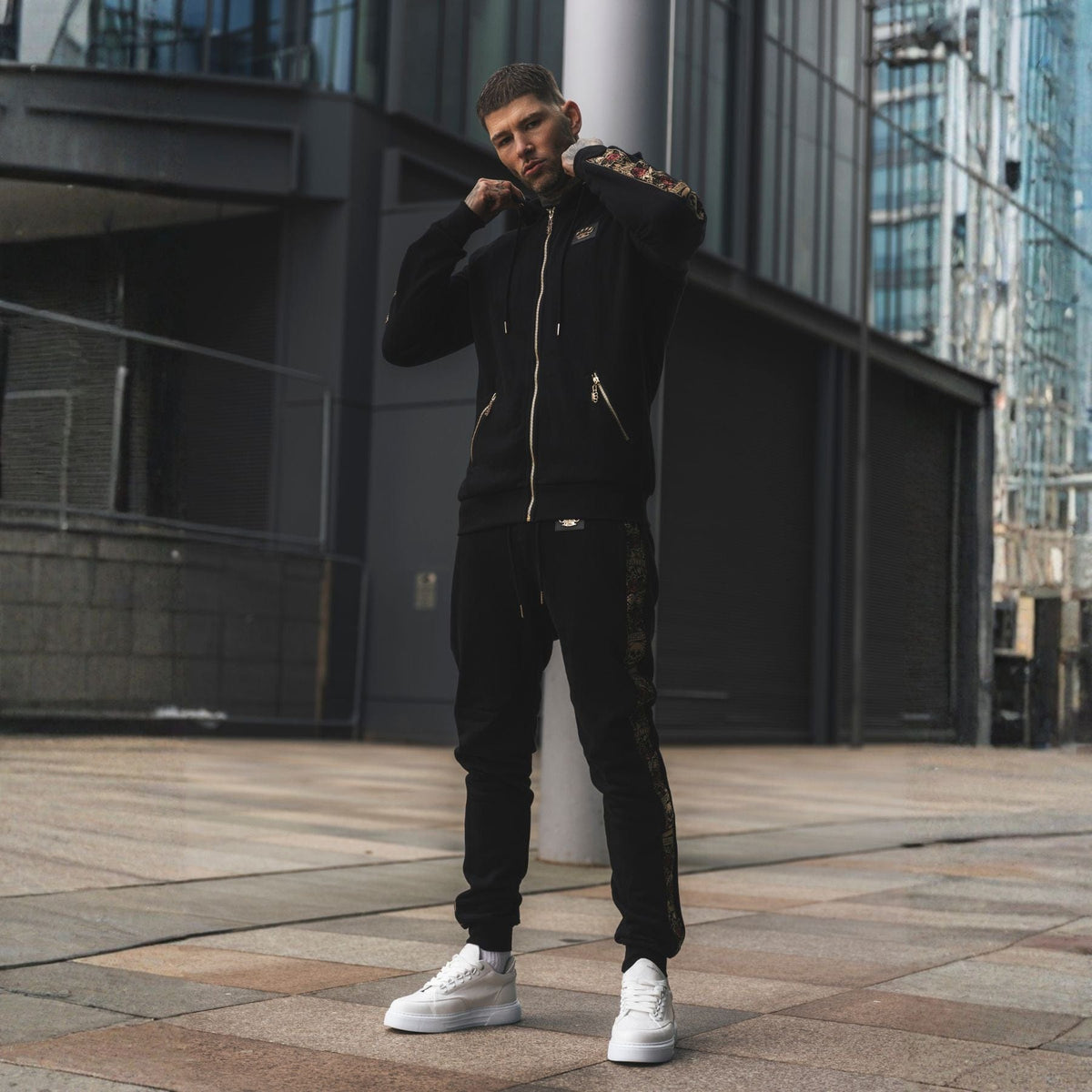 Jogger LFR Tracksuit nero indossato da modello con felpa coordinata e sneakers bianche in città