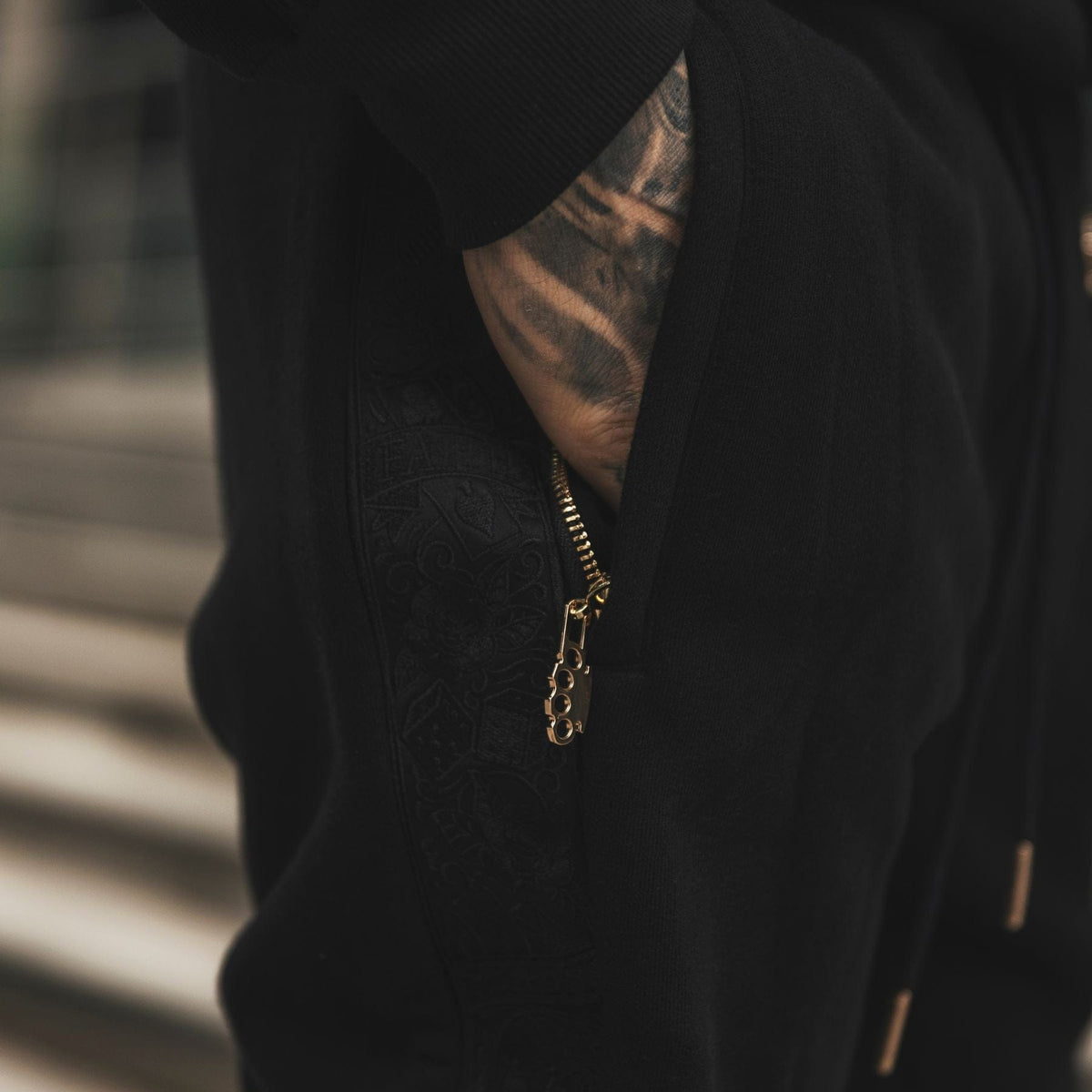 Primo piano della zip della tasca con tiretto logo MVL sul jogger LFR Tracksuit nero, indossato