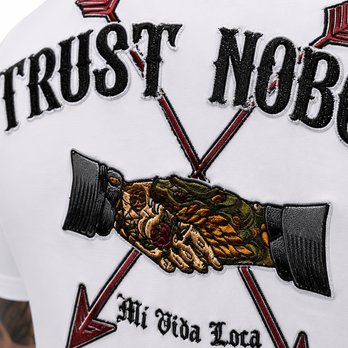 Zbliżenie haftu Trust nobody na plecach: uścisk dłoni między dwiema strzałami z napisem Mi Vida Loca