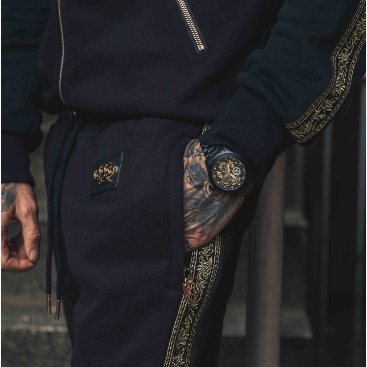 Pantalon de jogging Mi Vida Loca Meander noir avec bande brodée dorée et logo MVL, porté par un mannequin