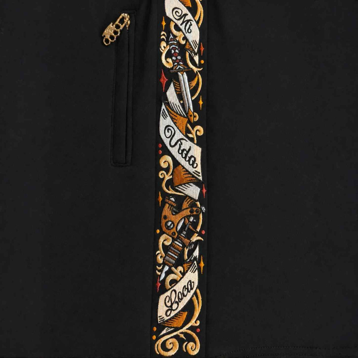 Close-up of the Savage ornate side band with Mi Vida Loca lettering and the zip with MVL logo puller