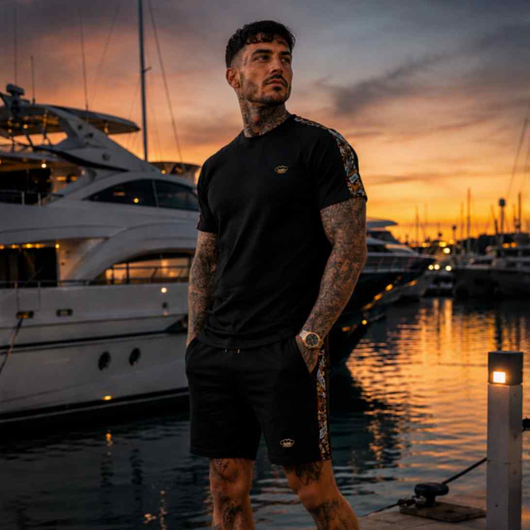 Model standing in the black Savage ornate summer set by yachts at sunset