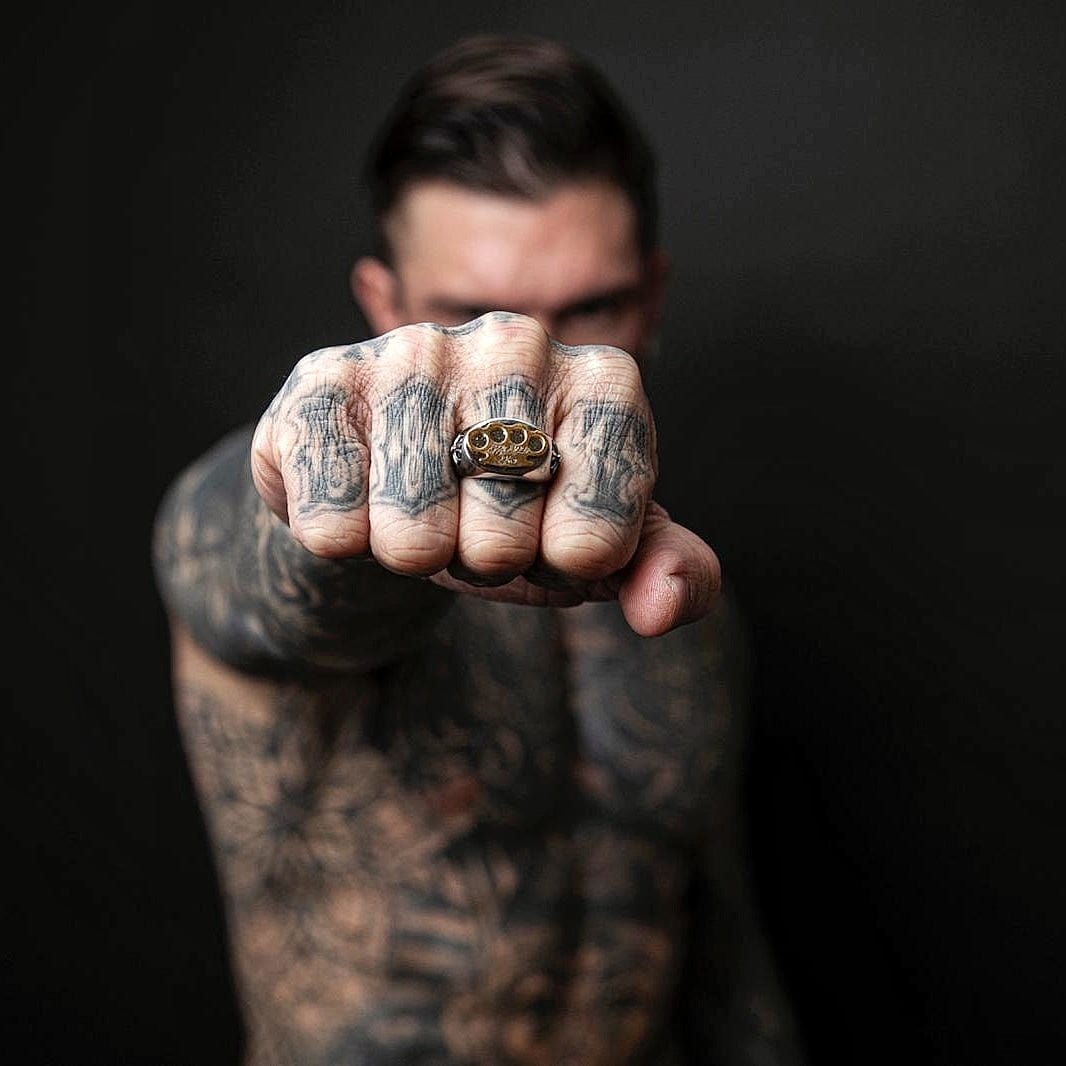 Model holding a fist forward with the silver MVL Logo ring on the finger