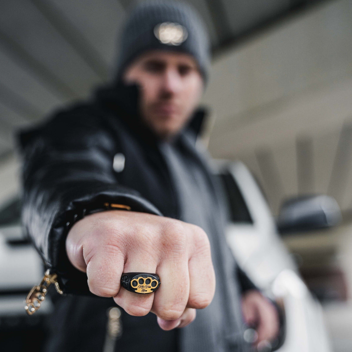 Pierścień MVL logo ring czarny na pięści modela skierowanej w stronę aparatu