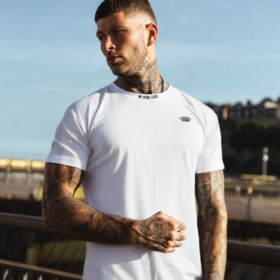Model in the white MVL Winning T-shirt, front view with gold logo on the chest